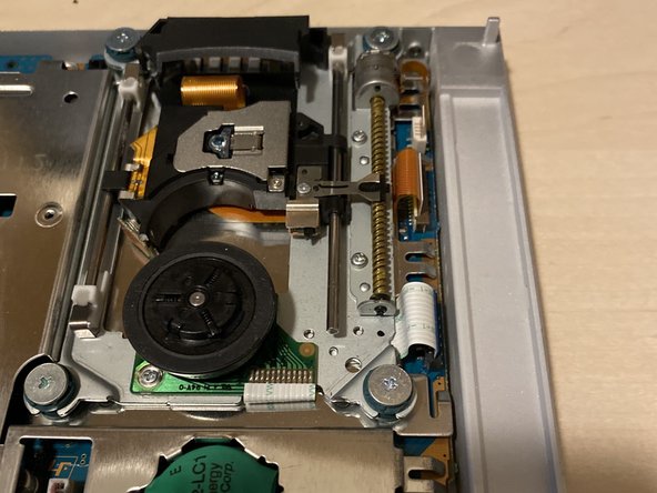 PlayStation 2 Slimline SPU-3170 Laser Replacement, Remove screws and white tab: crwdns2935265:05crwdnd2935265:03crwdnd2935265:03crwdne2935265:0