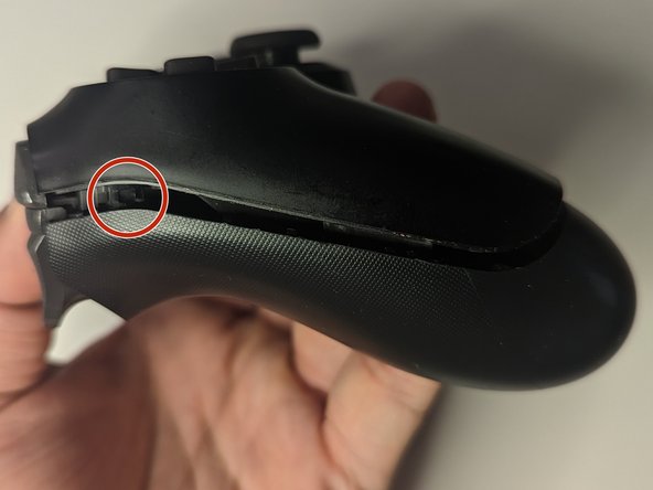 Important Step For Opening the DualShock 4 CUH-ZCT2U, Unlatch the side clip (left side): crwdns2935265:03crwdnd2935265:02crwdnd2935265:03crwdne2935265:0
