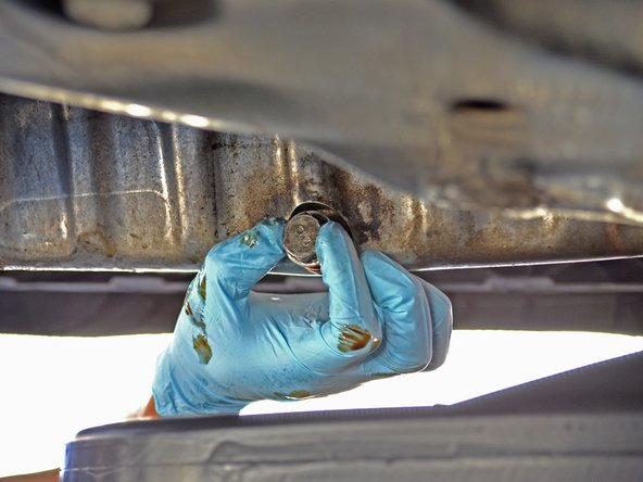 Replace the oil drain plug by first hand-tightening it.