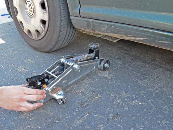 Slide the jack out from under the car.