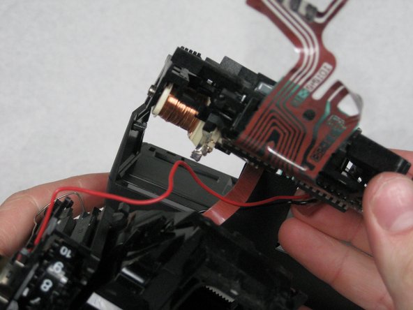 Remove the lens plate, flash compartment and wires from the camera.