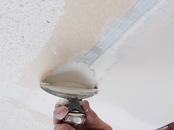 Your layering should completely conceal the mesh tape; pay particular attention to overlapped corners where it is thicker—the idea is to blend the new piece with the existing ceiling so the repair isn't obvious. Pic 2.