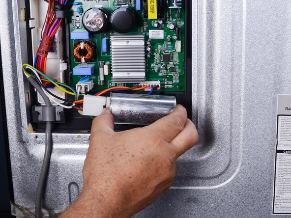 LG Refrigerator Compressor Run Capacitor Replacement, Unclip the capacitor: crwdns2935265:04crwdnd2935265:03crwdnd2935265:03crwdne2935265:0