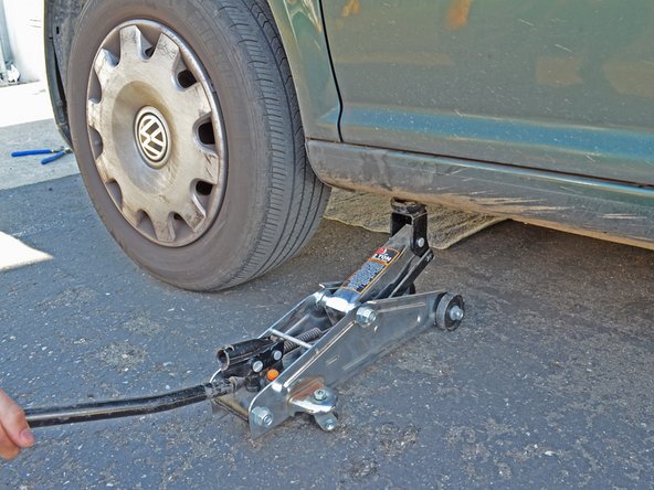 Slide the jack out from under the car.