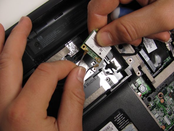 Disconnect the two WLAN antenna cables from the WLAN module.