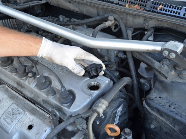 Twist the cap counter-clockwise and remove it from the oil filler hole.