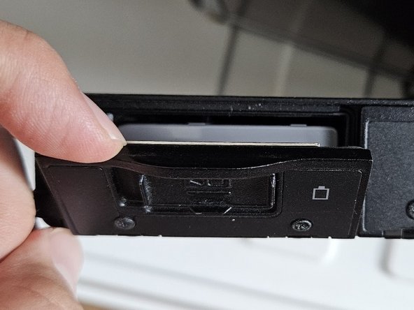 Replacement of Panasonic Toughbook CF-19 Battery, Unlock and open the battery compartment door: step 3, image 3 of 3