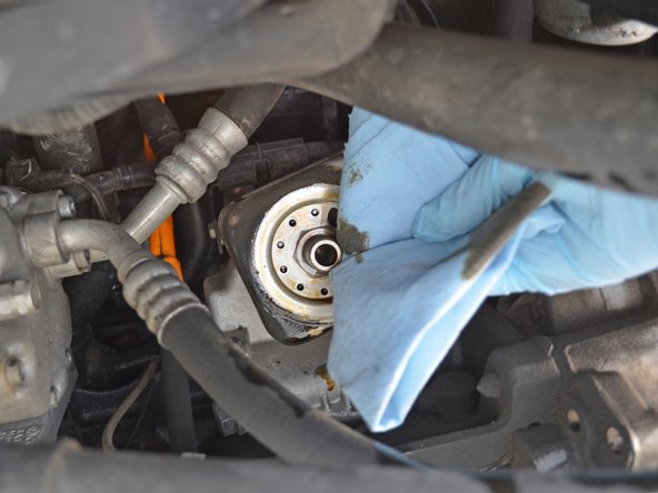 Use a rag or towel to wipe off any excess oil around the filter threads.