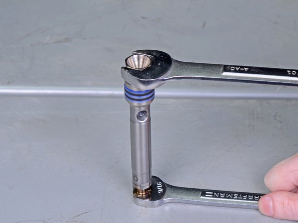 You can secure the piston rod in a vise, or use a 9/16&quot; wrench to secure the bottom of the piston rod as you unscrew and loosen the bolt.