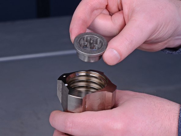 Use a pick tool to remove the metal ball seat from the bottom of the intake valve.