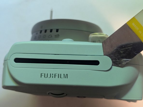 Fujifilm Instax Mini 9 Camera Shell Replacement, Remove the Film Ejection Slot Cover: crwdns2935265:010crwdnd2935265:02crwdnd2935265:03crwdne2935265:0