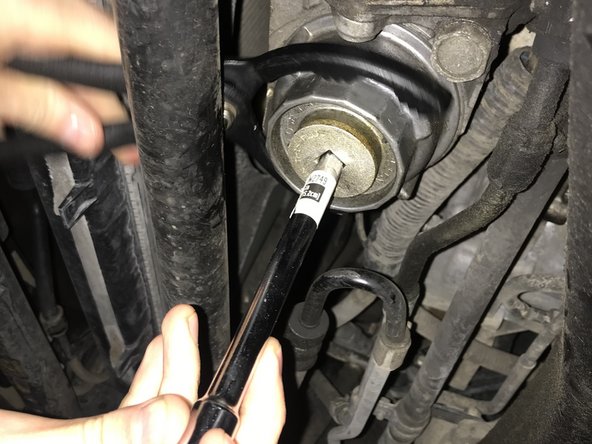 Then insert a ⅜ socket and slowly turn counterclockwise to loosen only the oil filter cap. This will expose the oil filter drain bypass.