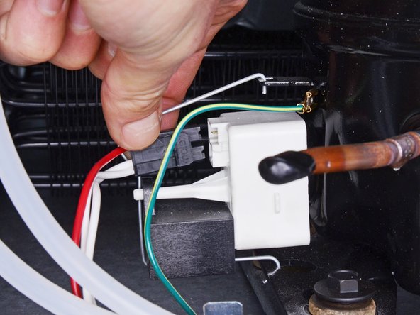 Whirlpool Refrigerator Start Relay Assembly Replacement, Disconnect the start relay assembly: crwdns2935265:04crwdnd2935265:03crwdnd2935265:03crwdne2935265:0