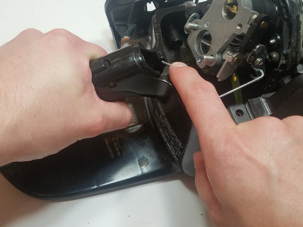Pull and hold the throttle trigger to expose the attachment point for the trigger-portion of the throttle linkage