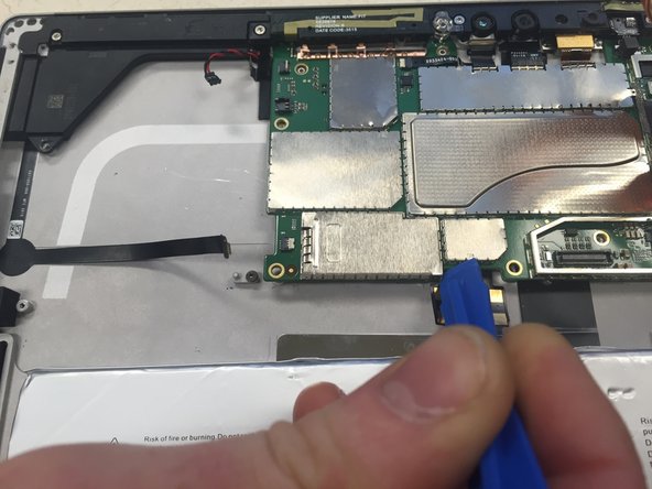 Use plastic opening tool to remove metal casing at the bottom left corner of the motherboard.