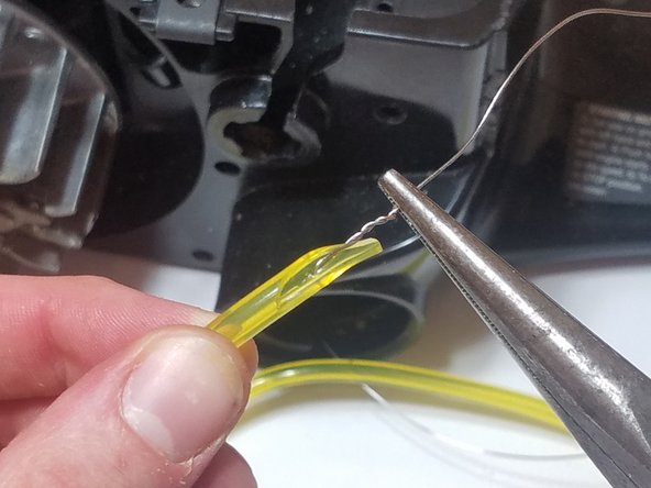 Pierce the wire through the fuel line and twist the wire with pliers
