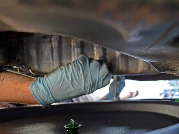 Use a 19 mm box end wrench or socket wrench to loosen the oil drain plug.