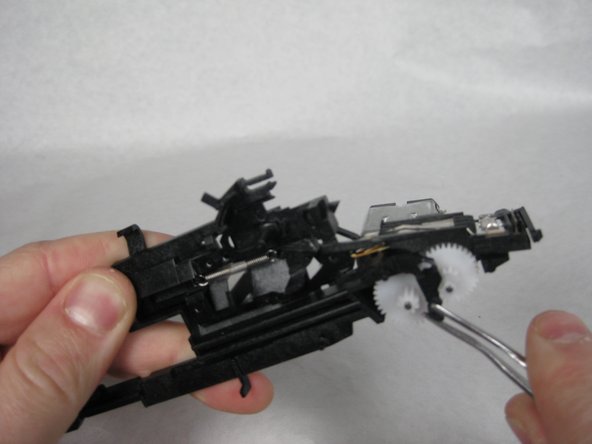 Pull the &quot;L&quot; shaped black plastic piece off of its pin.