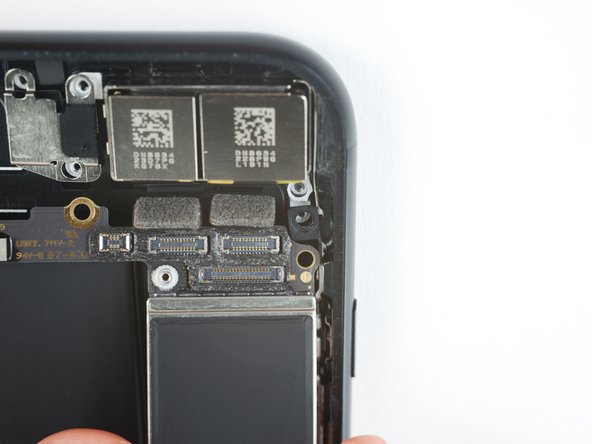 During reassembly, note the position of the black grounding clip at the top right edge of the logic board, near the rear cameras. The logic board should slide underneath the clip.