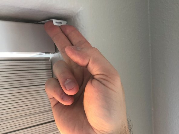 Unhook the end clips on the window blind by pulling with your fingers toward yourself in an upward motion.