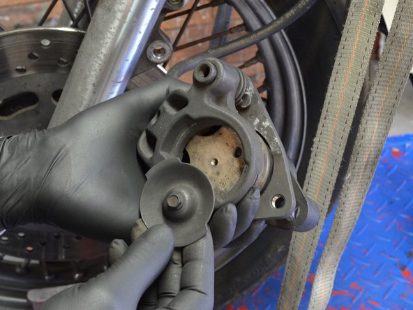 Remove the stationary brake pad cover from the brake assembly.