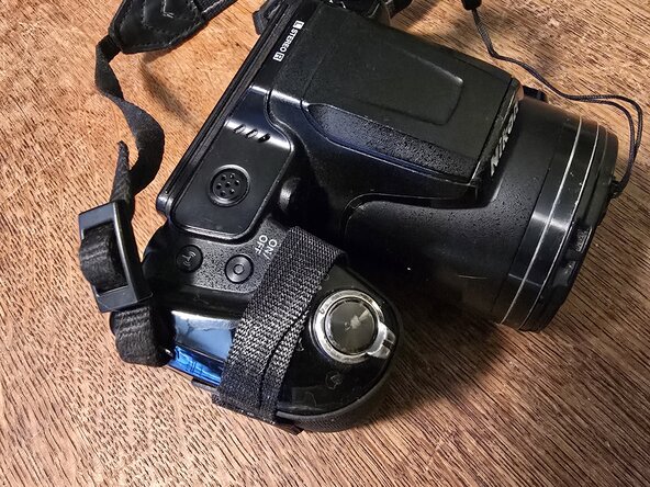 Nikon Coolpix L840 battery cover in place with Velcro strap: crwdns2935265:02crwdnd2935265:01crwdnd2935265:02crwdne2935265:0