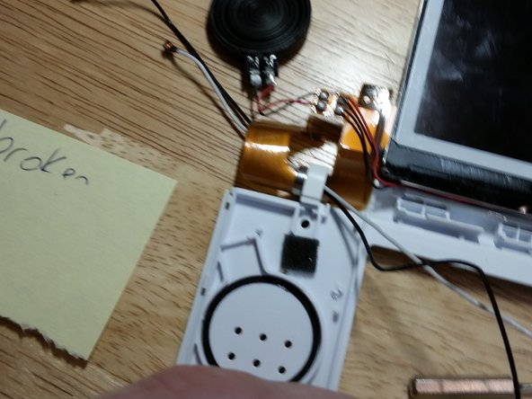 Noting the routing of the black and white wires for later reassembly, remove the microphone and Wi-Fi antenna, carefully pulling the wires through the center of the flex cable so as not to cause any damage.