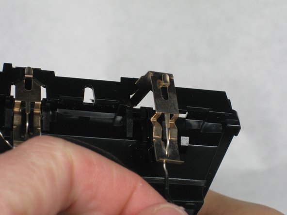 When you find the brass tab, pull it up. When the tab is free, remove the tab from the black wire.