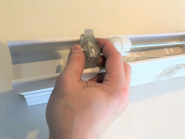 Remove the tilt wand mechanism by sliding it off the center rod.