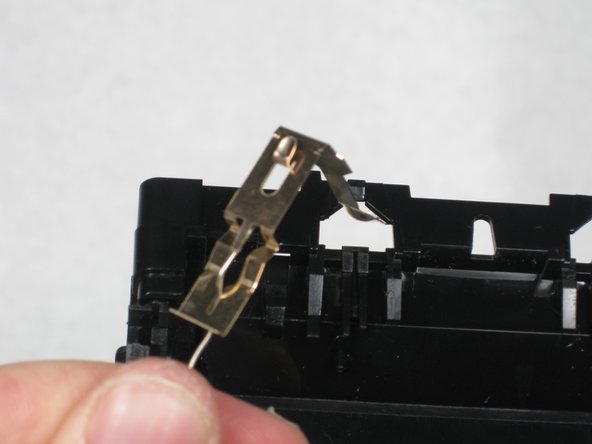Remove the metal band from behind the brass clip.
