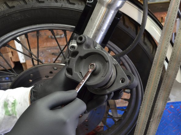 Remove the stationary brake pad cover from the brake assembly.