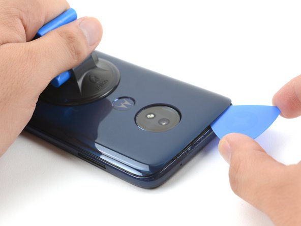 Slide the pick along the gap at the top of the phone to slice through the adhesive securing the rear cover to the midframe.