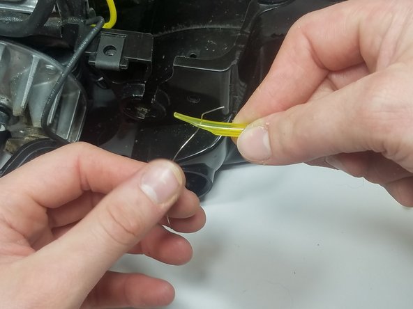 Pierce the wire through the fuel line and twist the wire with pliers