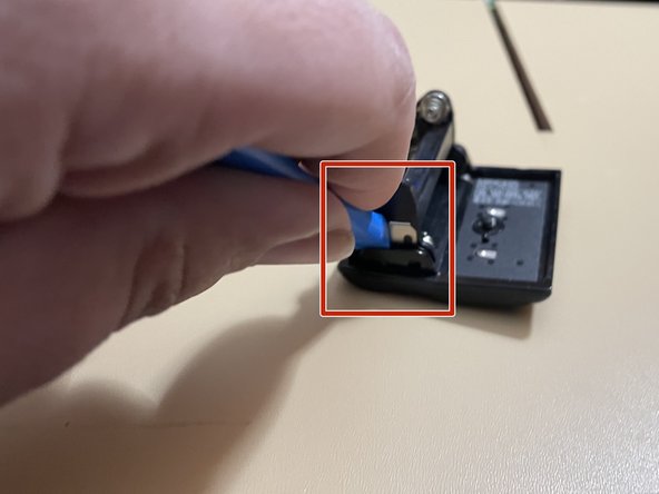 (AAA) Cleaning battery leakage (Maxxum 5000/7000), Remove the battery retention clip: crwdns2935265:04crwdnd2935265:02crwdnd2935265:03crwdne2935265:0