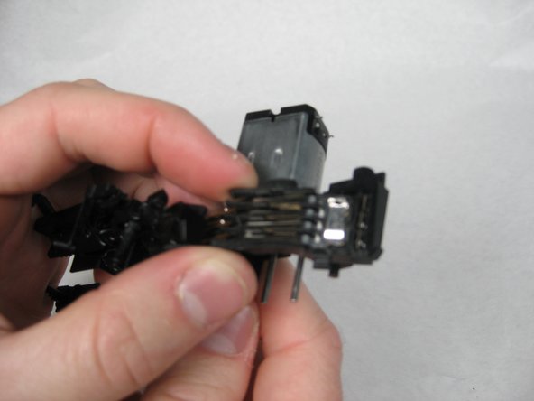 Lift the plastic box containing several long metal tabs