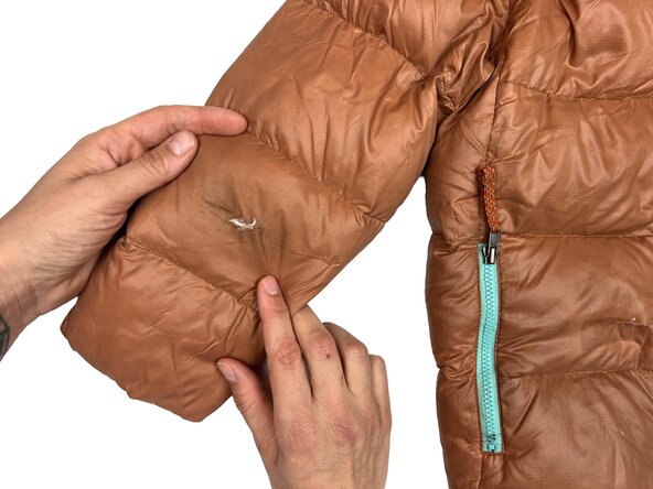 Réparer une doudoune à l’aide d'un patch adhésif, Évaluer les dégâts: étape 1, image 1 de 2