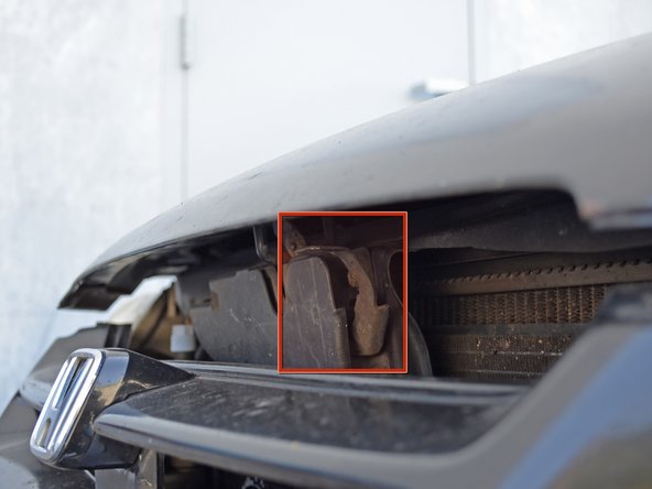 Locate the hood release latch under the hood. Use one hand to press up on the latch while you lift the hood.