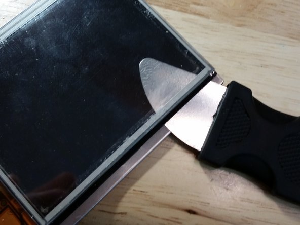 Slide the metal spudger under the black sticker and carefully work your way around the assembly, avoiding the flex cables. This step is easier than it looks, but only perform this step if the screen or the digitizer needs to be replaced. If both are functional, this step is unnecessary. Thoroughly clean both pieces with alcohol afterwards.