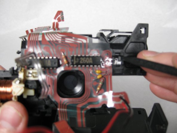 Remove the small LED from its clip, and then lift the flat wire array and the flash compartment away from the back of the lens plate.