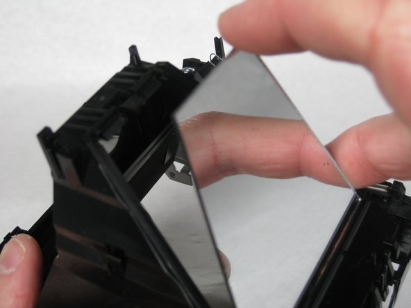 Lift the tab with the spudger and pop out the mirror.