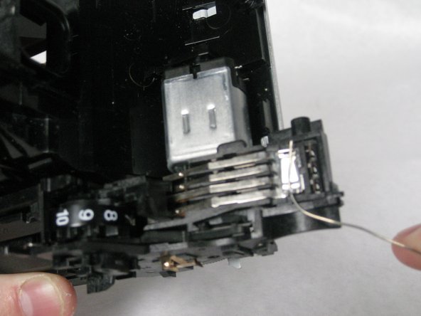 then unhook the uncovered wire from the the final latch located on the top of the plastic extension.