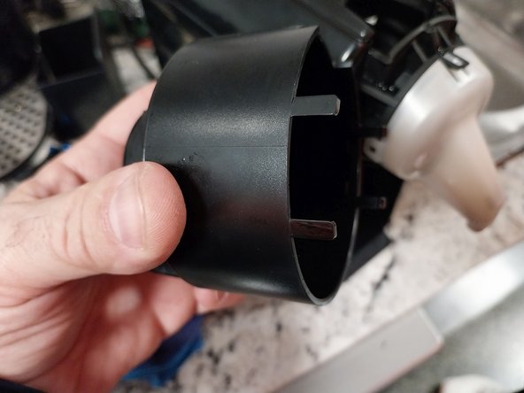 Disassembly of coffee outlet nozzle Krups Nespresso XN100 coffee maker due to clogging, losing excess water., Removing  the mouthpiece cover.: step 8, image 2 of 3