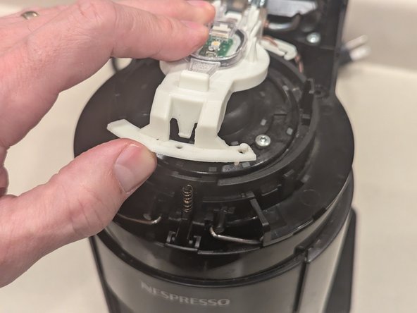 Nespresso Vertuo Evoluo Bearing Replacement, Re-attach white button bracket: crwdns2935265:017crwdnd2935265:02crwdnd2935265:03crwdne2935265:0