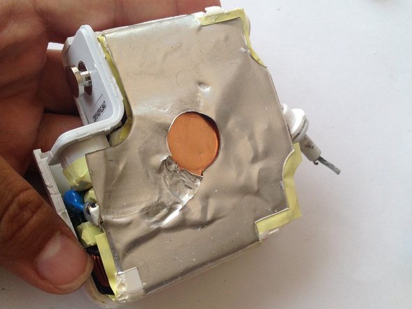 Insert the screwdriver into the top part of the charger and carefully separate the foil from the plastic enclosure. Be careful as to not rip off the foil from the inner part of the charger.