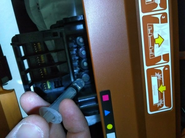 Fill the syringe with distilled water and spray the small holes on the print-head. Use the cotton swabs to  scrub and clean the crevices.